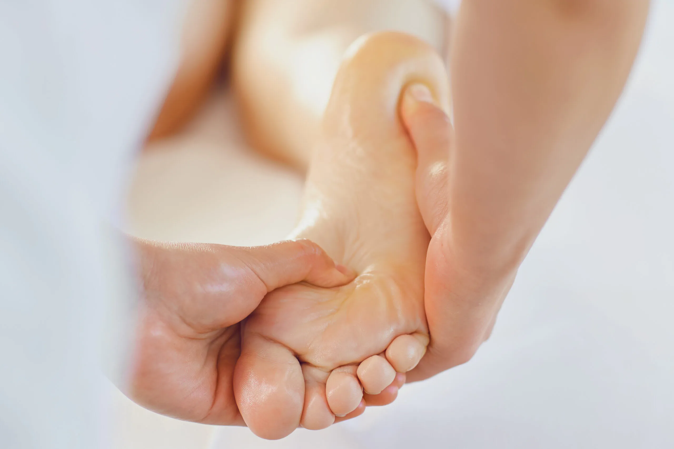 Massage des pieds dans la salle de massage. Un masseur fait une réfléxolgie plantaire à une femme.