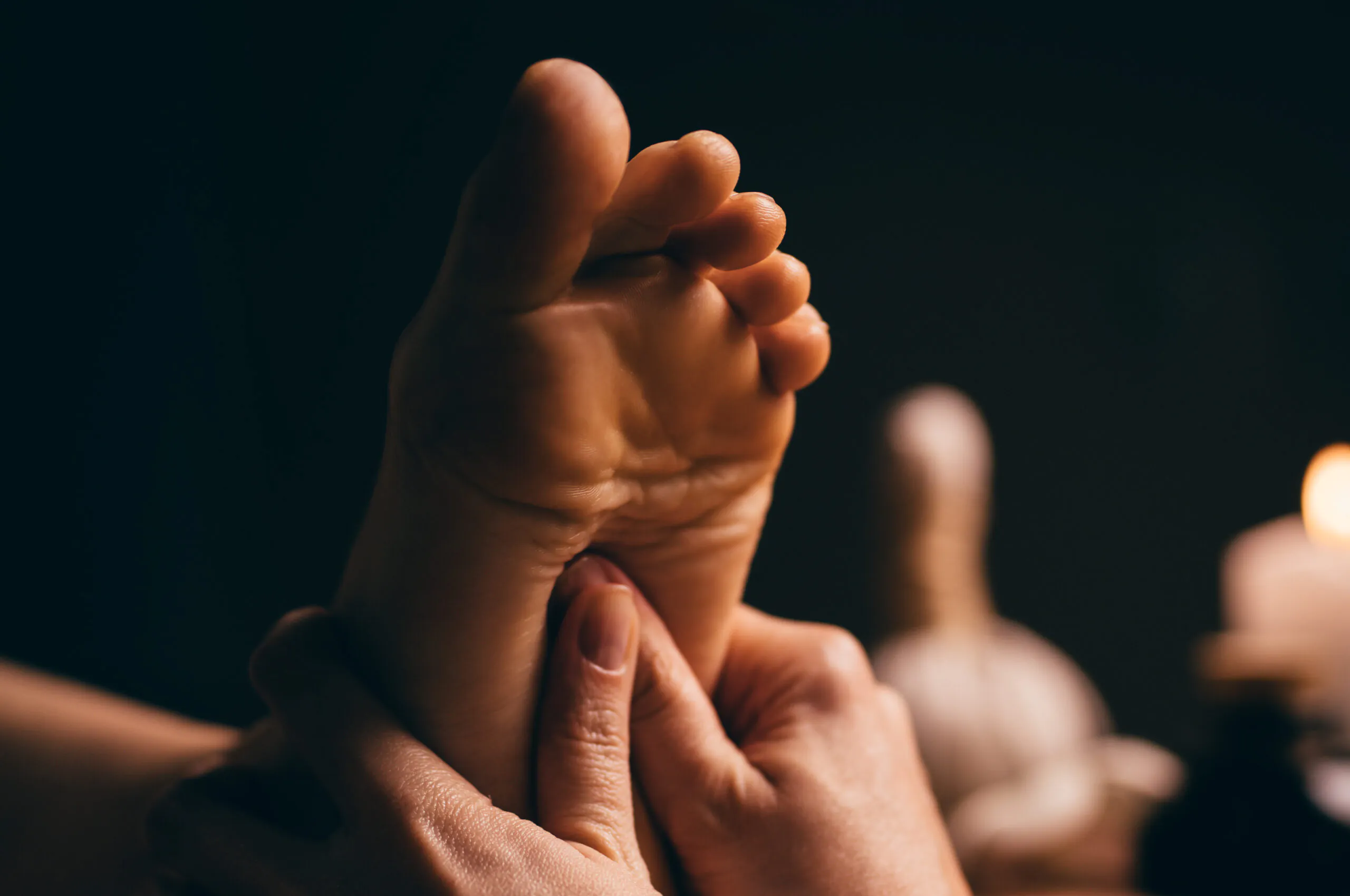 Professional foot massage close up. Authentic shot of luxury spa treatment. Charming light. Shallow depth of field. Stylized and colored.